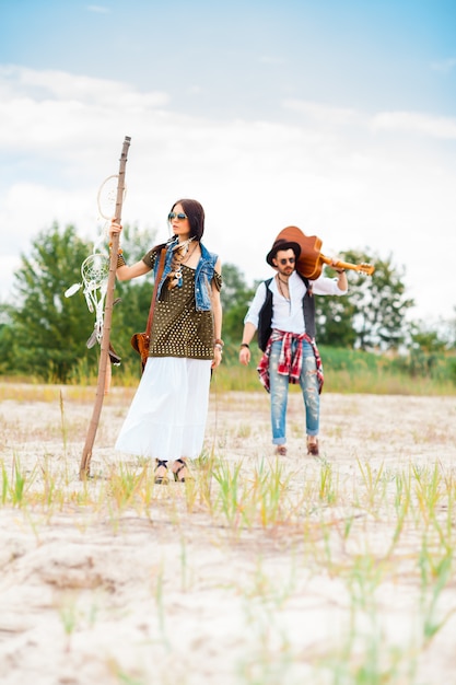 Man and woman as boho hipsters against blue sky