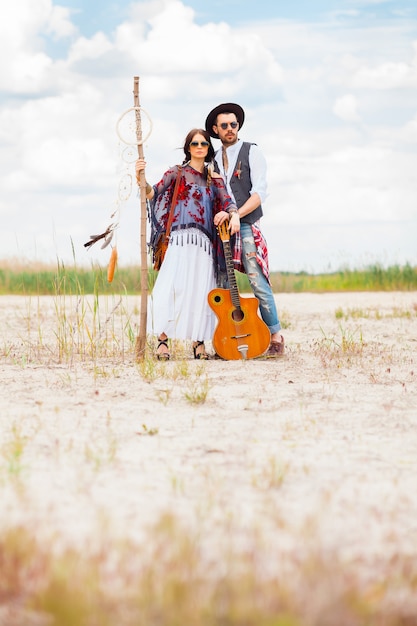 Free photo man and woman as boho hipsters against blue sky