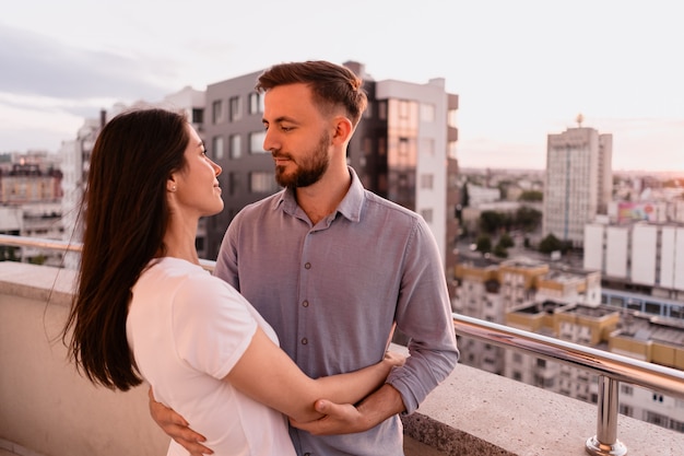 Man and woman on balcony at sunset in the city