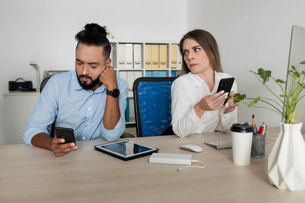 Man and woman being addicted to their phones