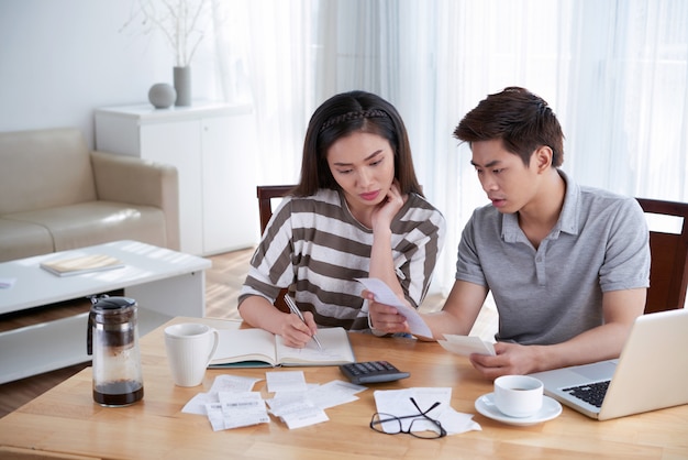 Man and woman calculating domestic budget at home