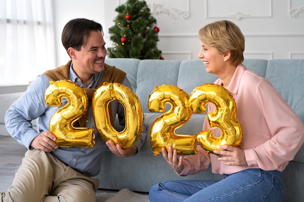 Free Photo man and woman celebrating new years eve at home together