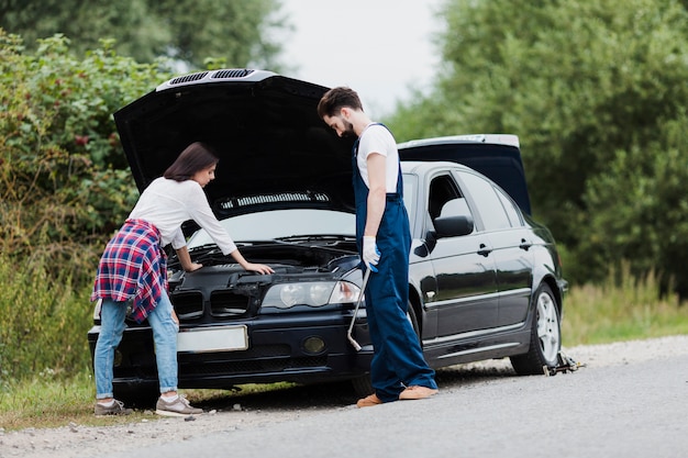 Free Photo man and woman checking car engine