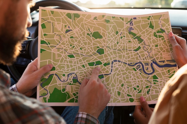 Free photo man and woman checking a map in the car