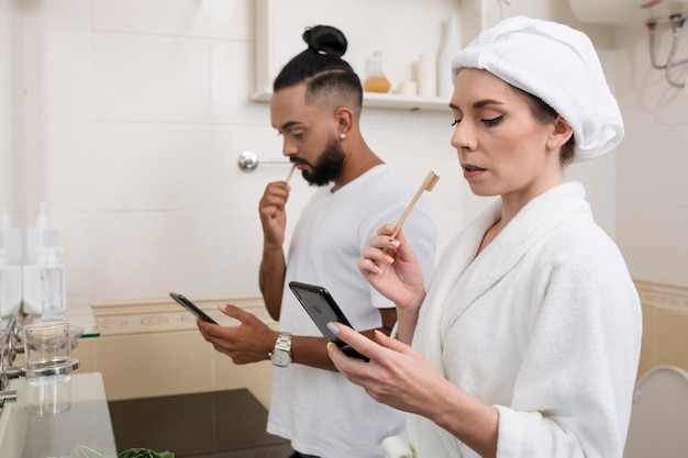 Man and woman checking their phones even in their bathroom