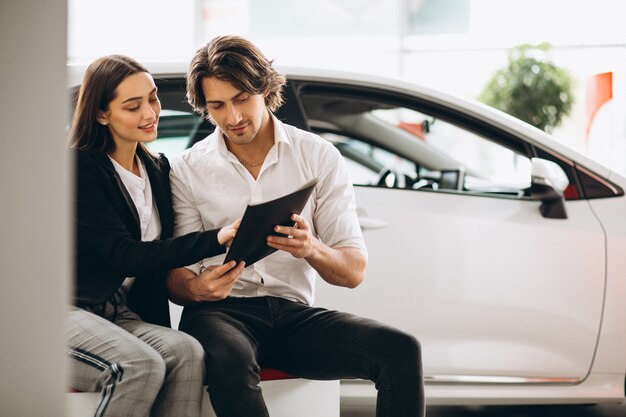 Man and woman choosing a car in a car showroom