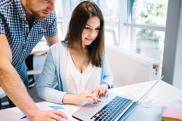 Man and woman collaborating at laptop