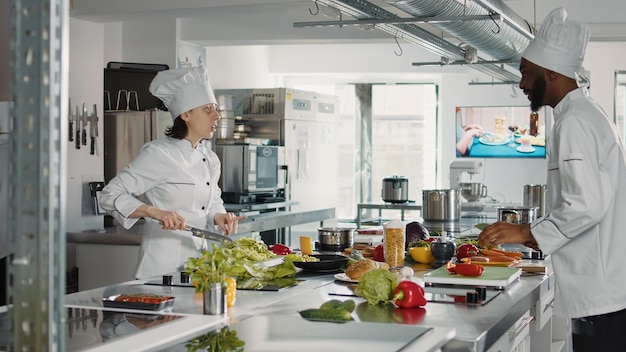 Man and woman cutting fresh ingredients to make gourmet dish