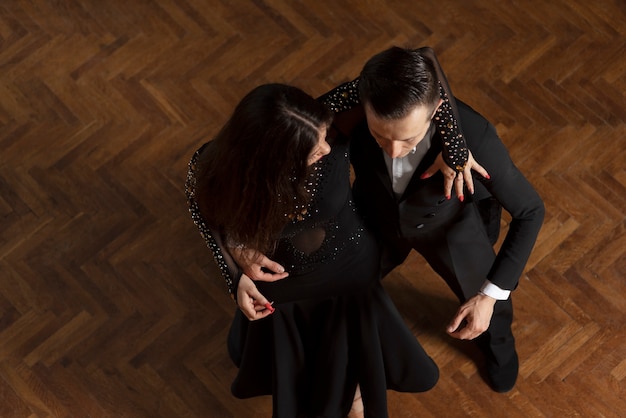 Free photo man and woman dancing together in a ballroom scene