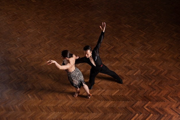 Free photo man and woman dancing together in a ballroom scene