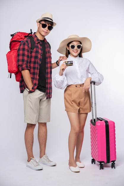 Man and woman dressed up wearing glasses to travel with suitcases