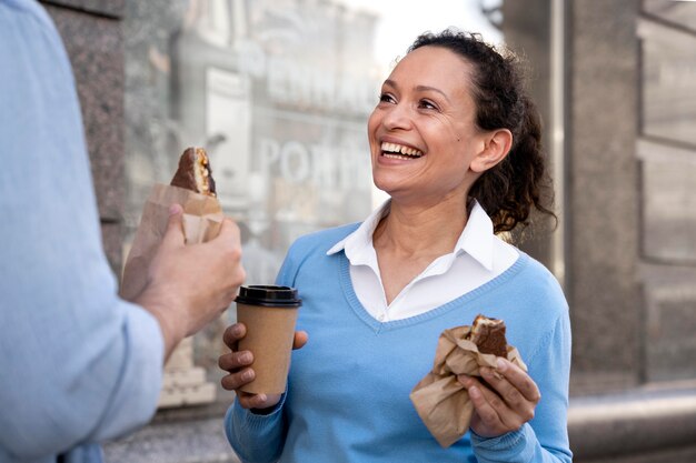 Man and woman enjoying takeaway food on the street