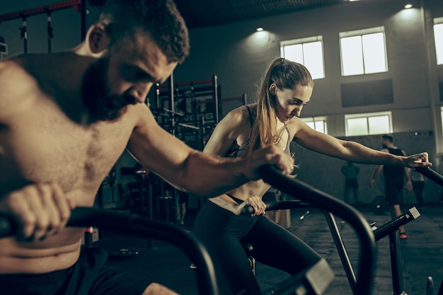 Free Photo man and woman during exercises in the fitness gym.