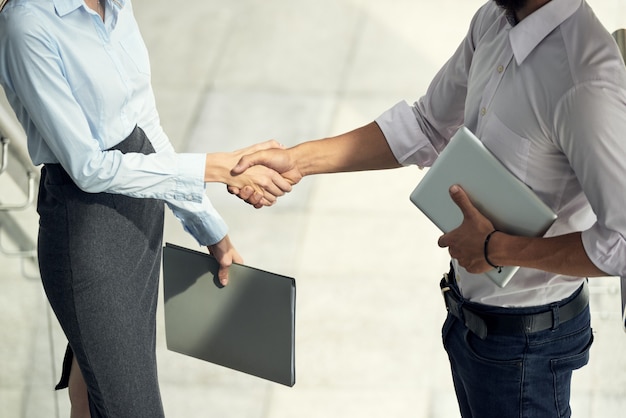 Man And Woman Greeting Each Other Shaking Hands In Office