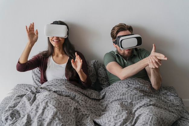 Man and woman having fun at home playing with virtual reality headset