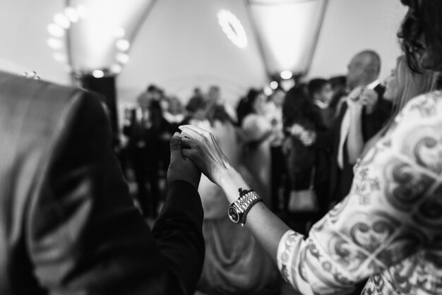 Man and woman hold their hands up while dancing