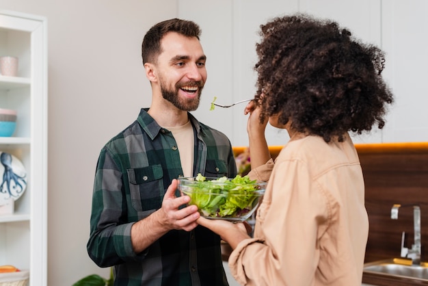 Man and woman holding a bowl of salad