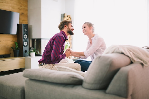 Free photo man and woman holding hands on sofa