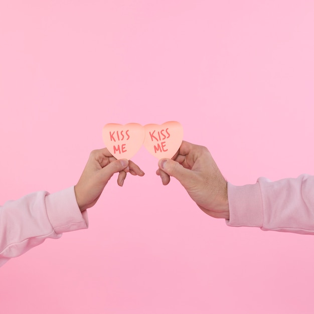 Man and woman holding paper decorative symbols of heart