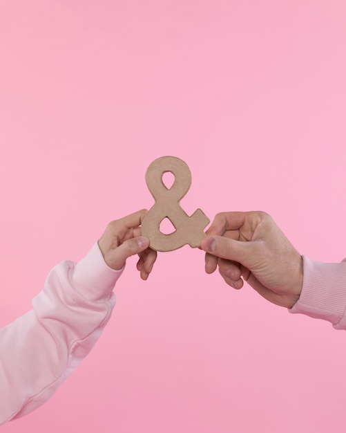 Free photo man and woman holding symbol of ampersand