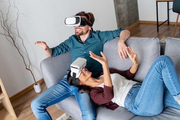 Free photo man and woman at home on the couch exploring virtual reality headset