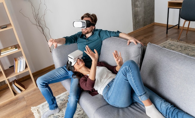 Free photo man and woman at home on the couch with virtual reality headset