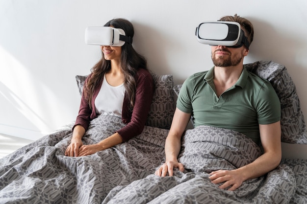 Free photo man and woman at home using virtual reality headset