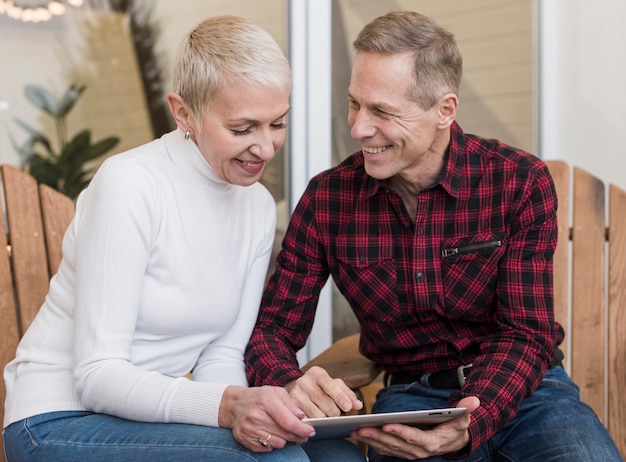 Free photo man and woman looking on their tablet