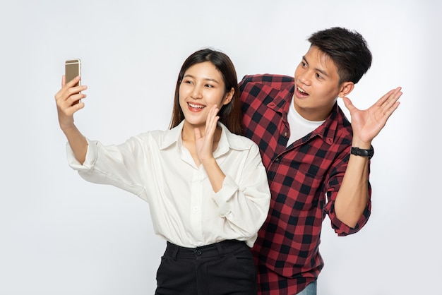 Man and woman make the fun of selfies from their smartphones