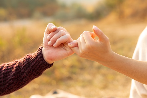 Free photo man and woman making a pinky promise