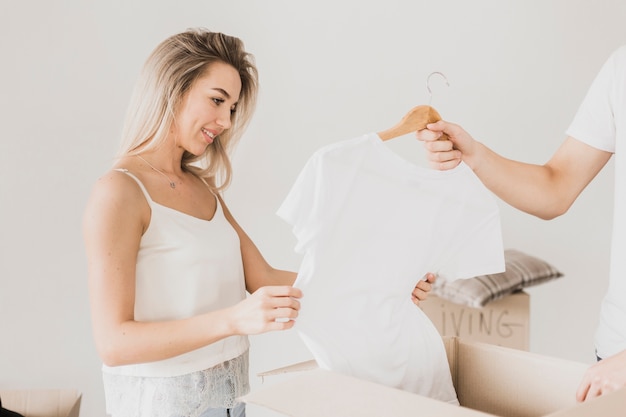 Free Photo man and woman packing t-shirt in box