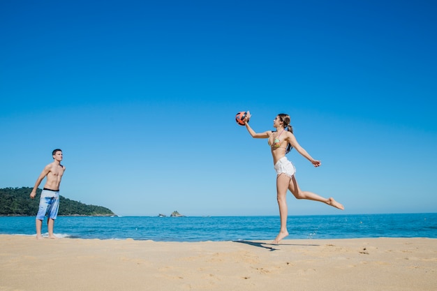 Free Photo man and woman playing beach volleyball