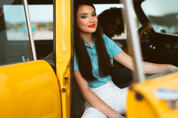 Man and woman posing in retro style with car