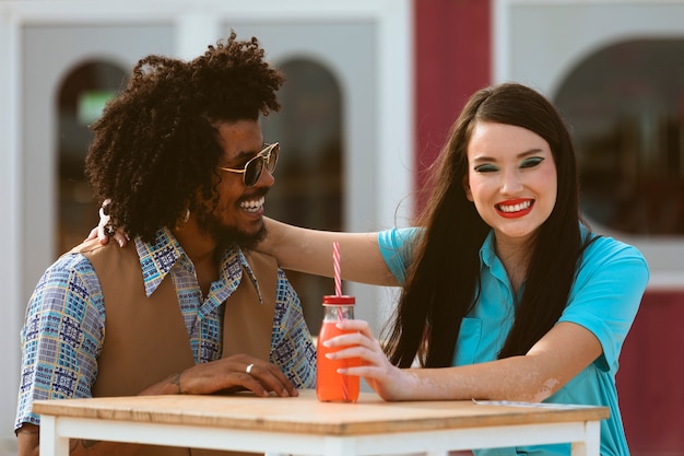 Man and woman posing together in retro style with beverage