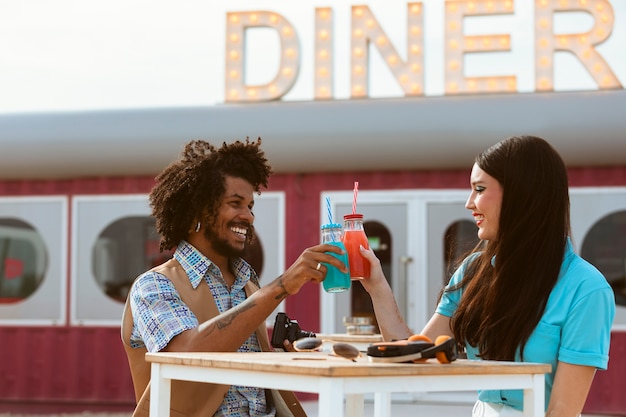 Man and woman posing together in retro style with beverage