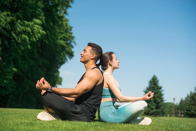 Man and woman practicing yoga outdoor