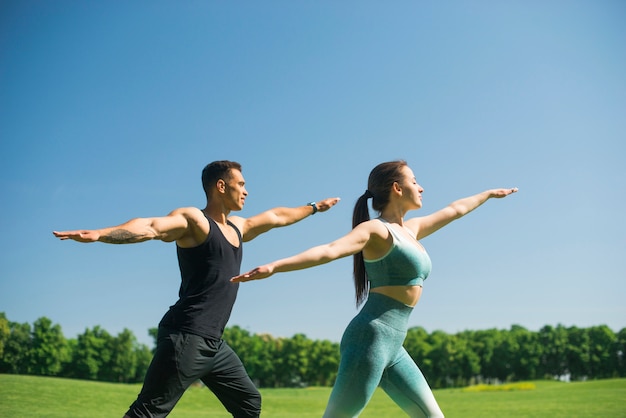 Free photo man and woman practicing yoga outdoor