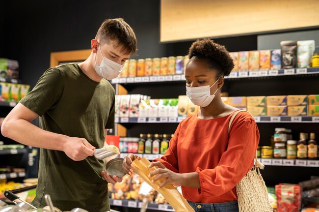 Man and woman shopping at the grocery store while wearing medical masks