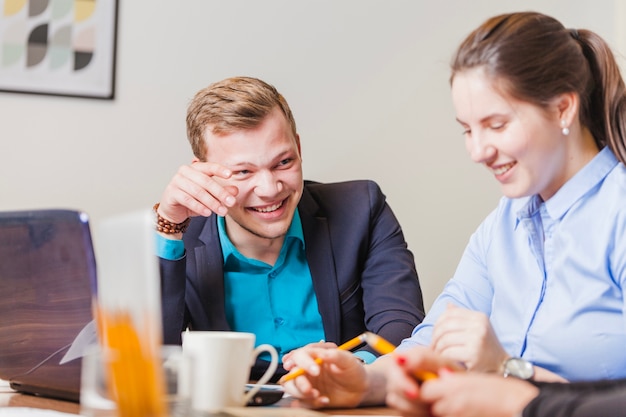 Man and woman sitting at desk smiling