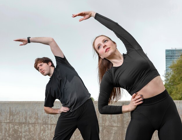 Man and woman in sportswear exercising outdoors