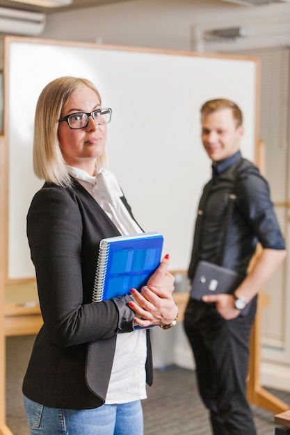 Free Photo man and woman standing against whiteboard