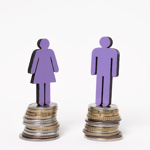 Free photo man and woman standing on equal piles of coins