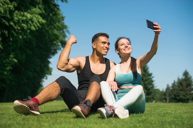 Man and woman taking a selfie in a park