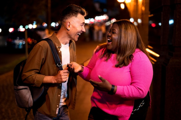 Man and woman talking at night in the city lights