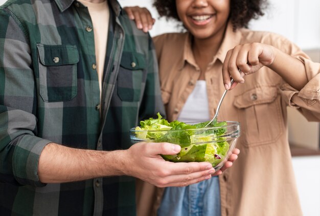 Free photo man and woman trying tasty salad