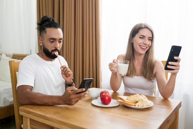 Man and woman using their phone in the kitchen