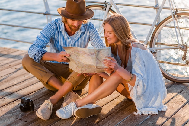 man and woman with blond hair boho hipster style fashion having fun together, looking in map sightseeing