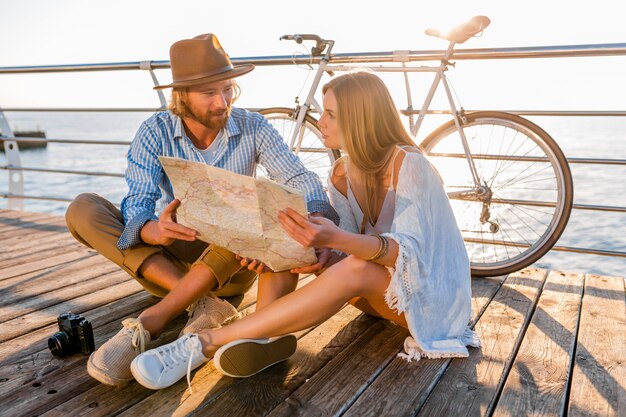 man and woman with blond hair boho hipster style fashion having fun together, looking in map sightseeing