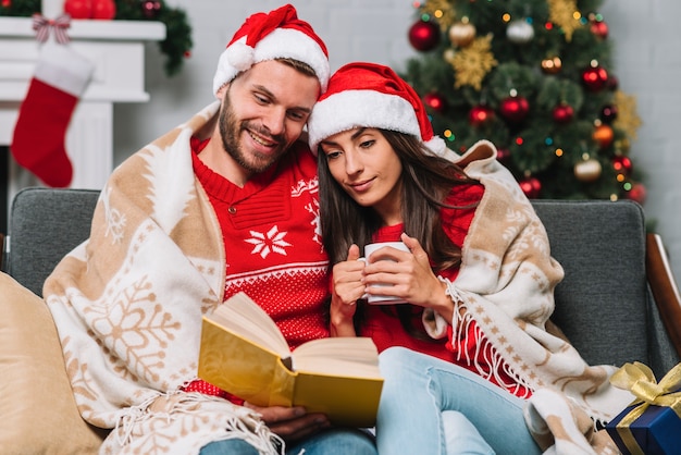 Man and woman with cup reading book