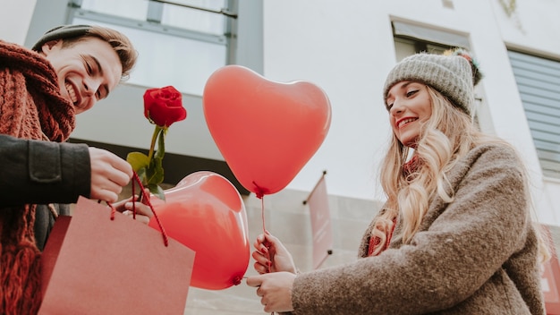 Free Photo man and woman with gifts and heart balloons